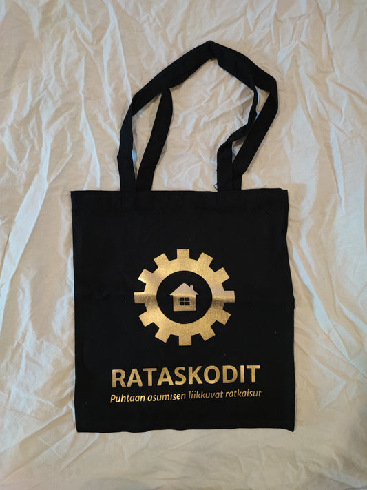 Rataskotien musta kassi kultaisella painetulla logolla